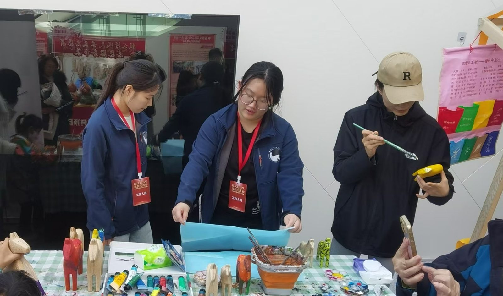 Painting wooden horses at the HOPE craft table