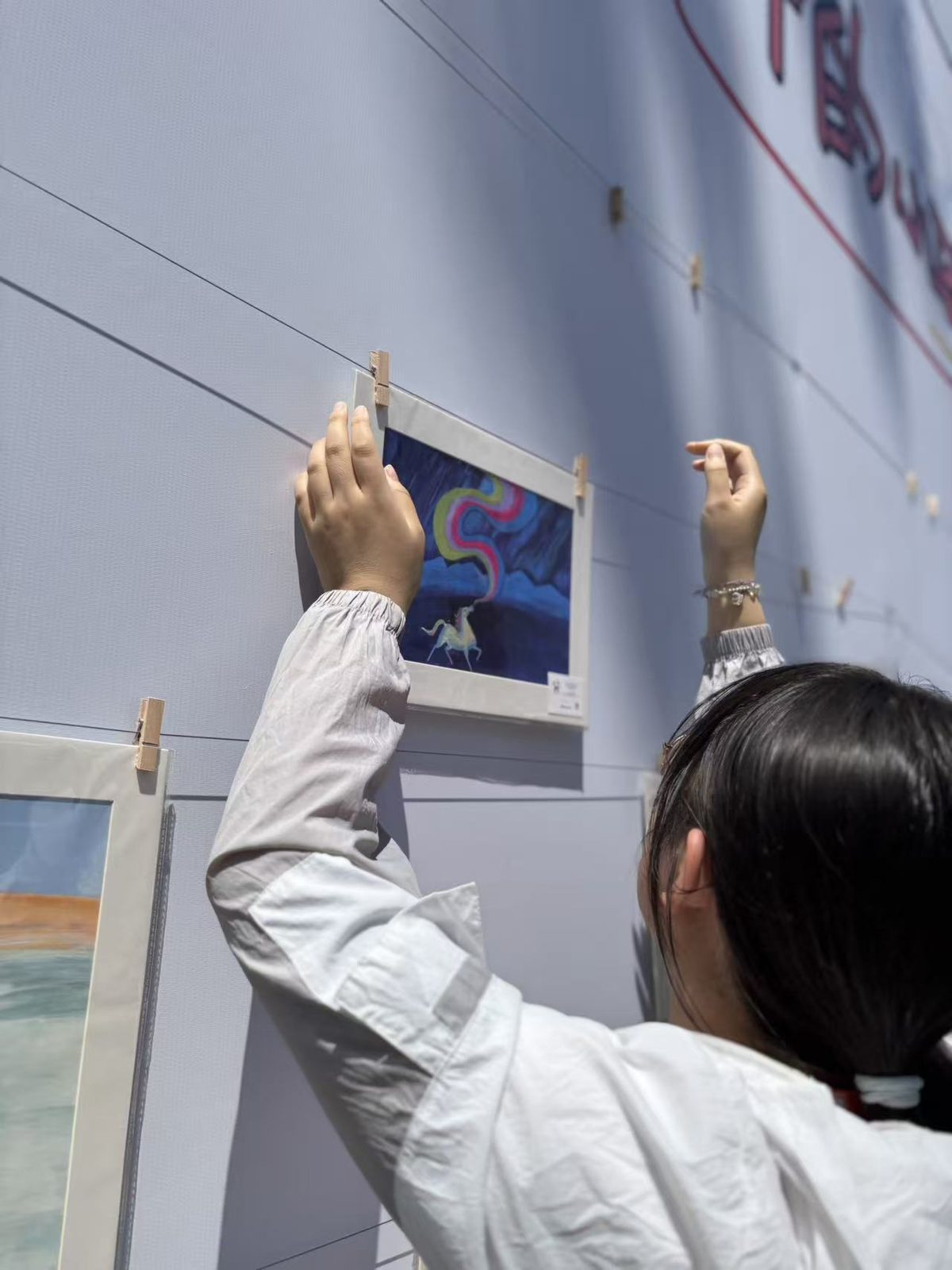Hanging children's artwork on the wall